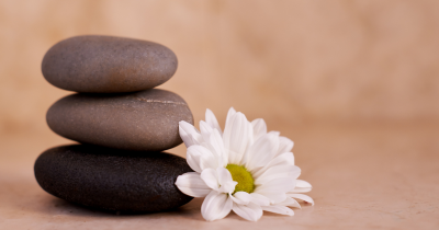 Stack of stones next to Daisy flower