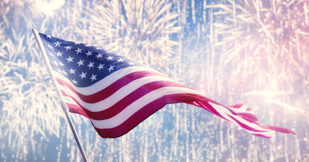 United States Flag Flying with Fireworks