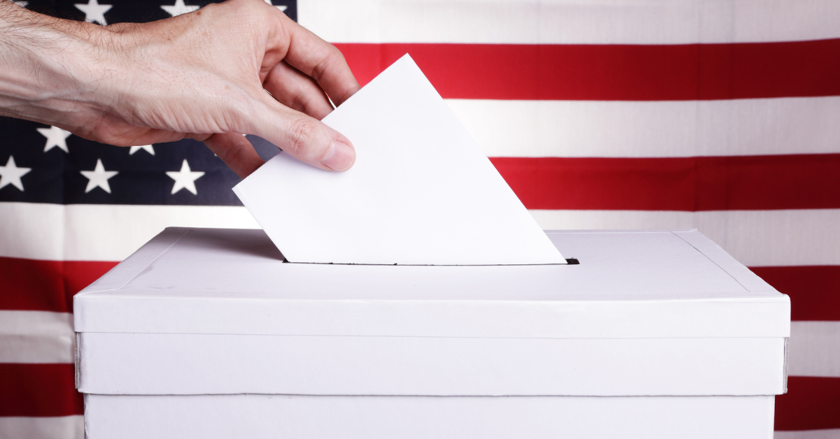 Hand of person casting a vote in a ballot.